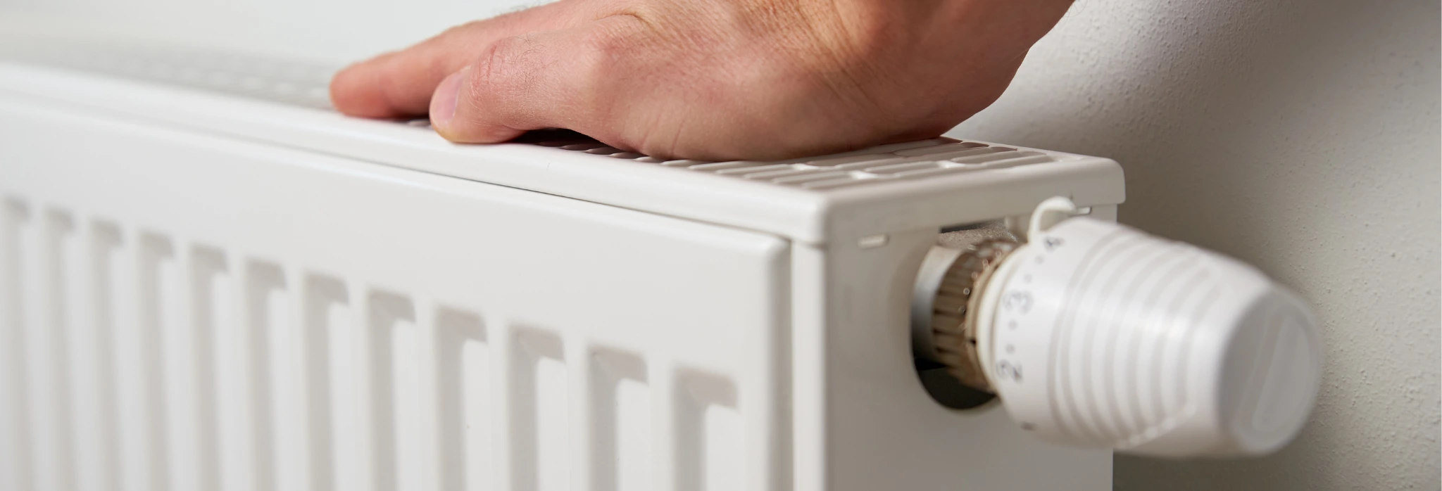 Χέρι ελέγχει θερμοκρασία σε καλοριφέρ.