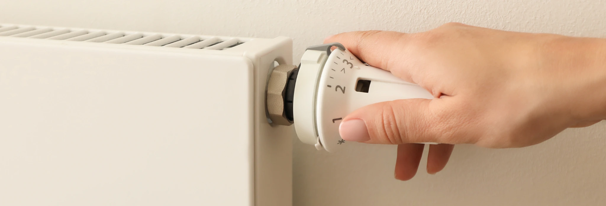 Χέρι ρυθμίζει θερμοκρασία στο καλοριφέρ.